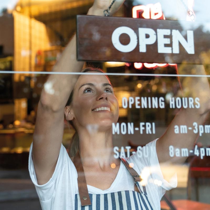 McLain Insurance Agency | Chesterfield, SC | young business owner turning open sign on door, business insurance